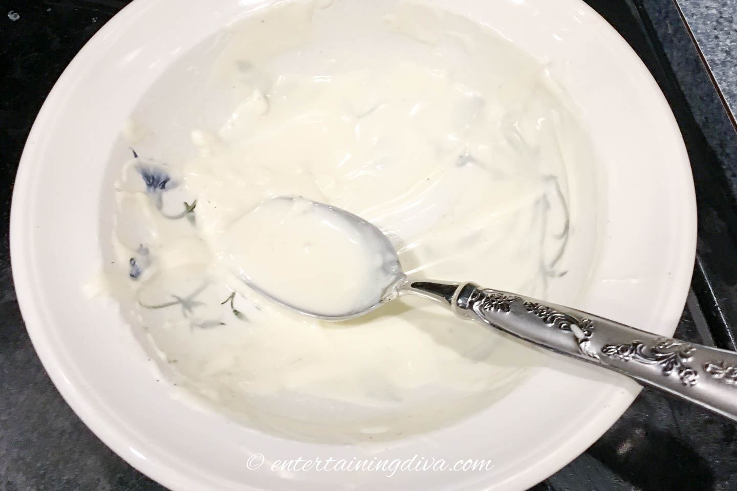 A bowl with melted white chocolate and a spoon