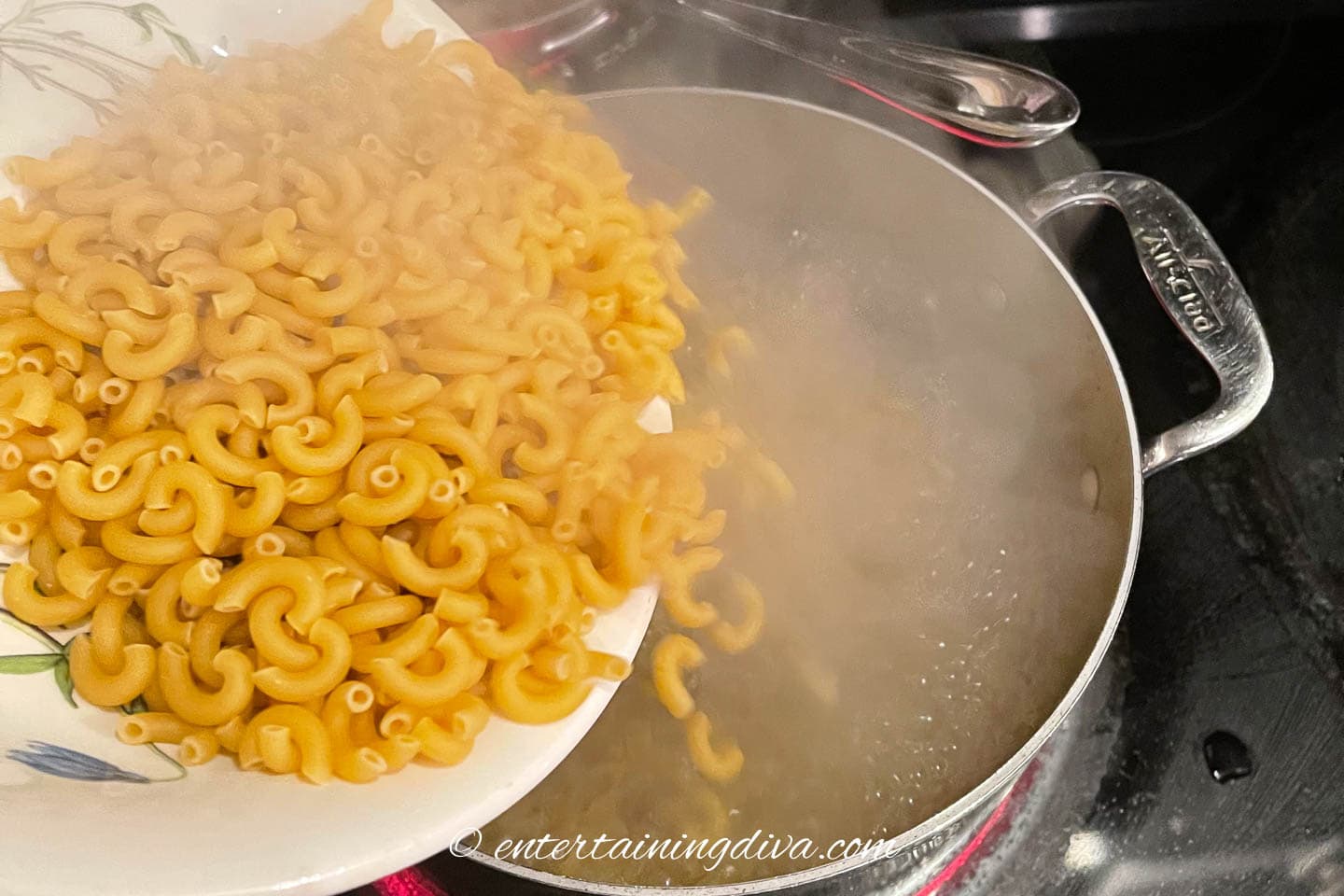macaroni pouring into a pot of boiling water
