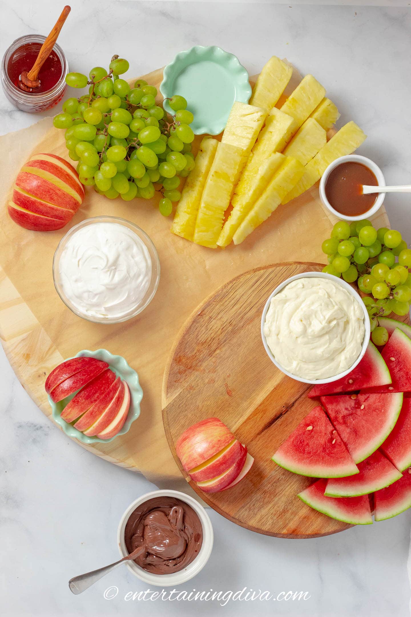 fruit charcuterie board with apples, pineapple, watermelon, grapes and dips