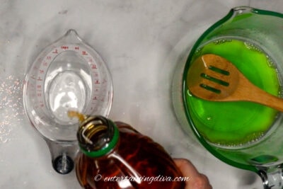 Apple juice being poured into a measuring cup