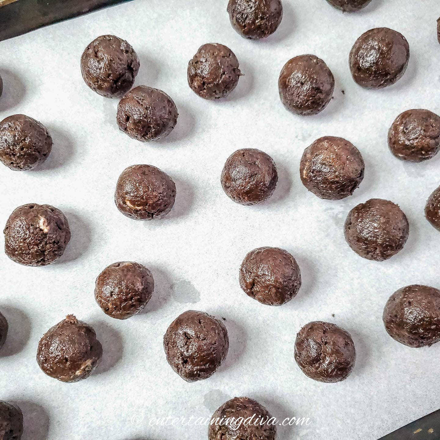 Rolled Oreo balls on a parchment-covered baking sheet