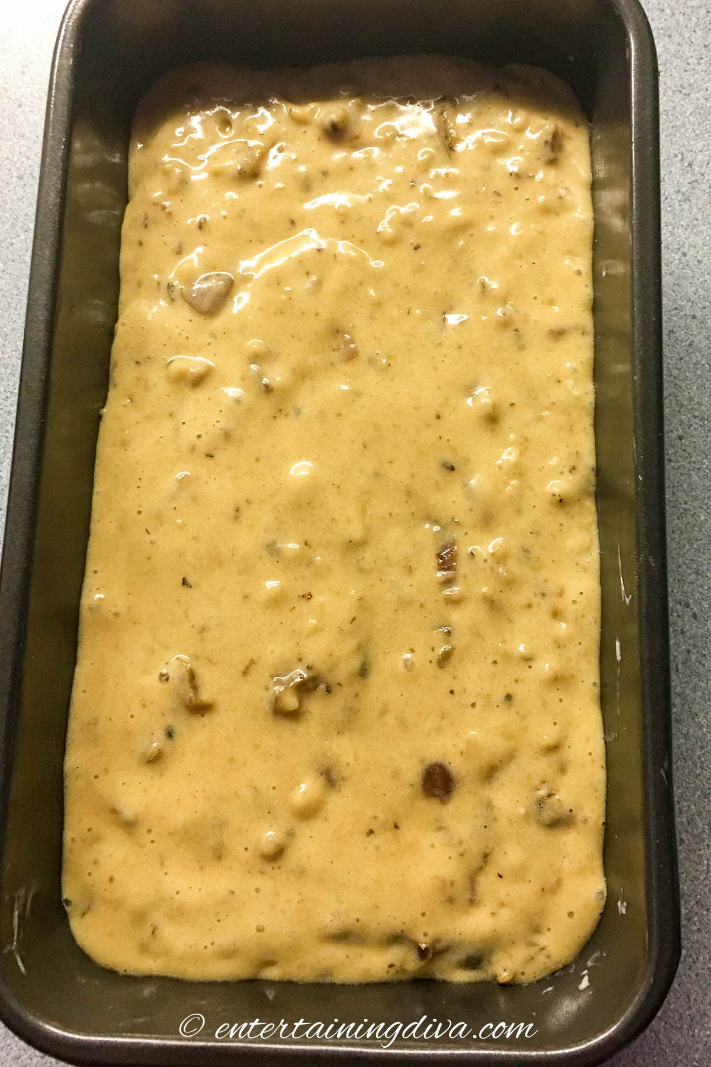 The bread batter in a loaf pan