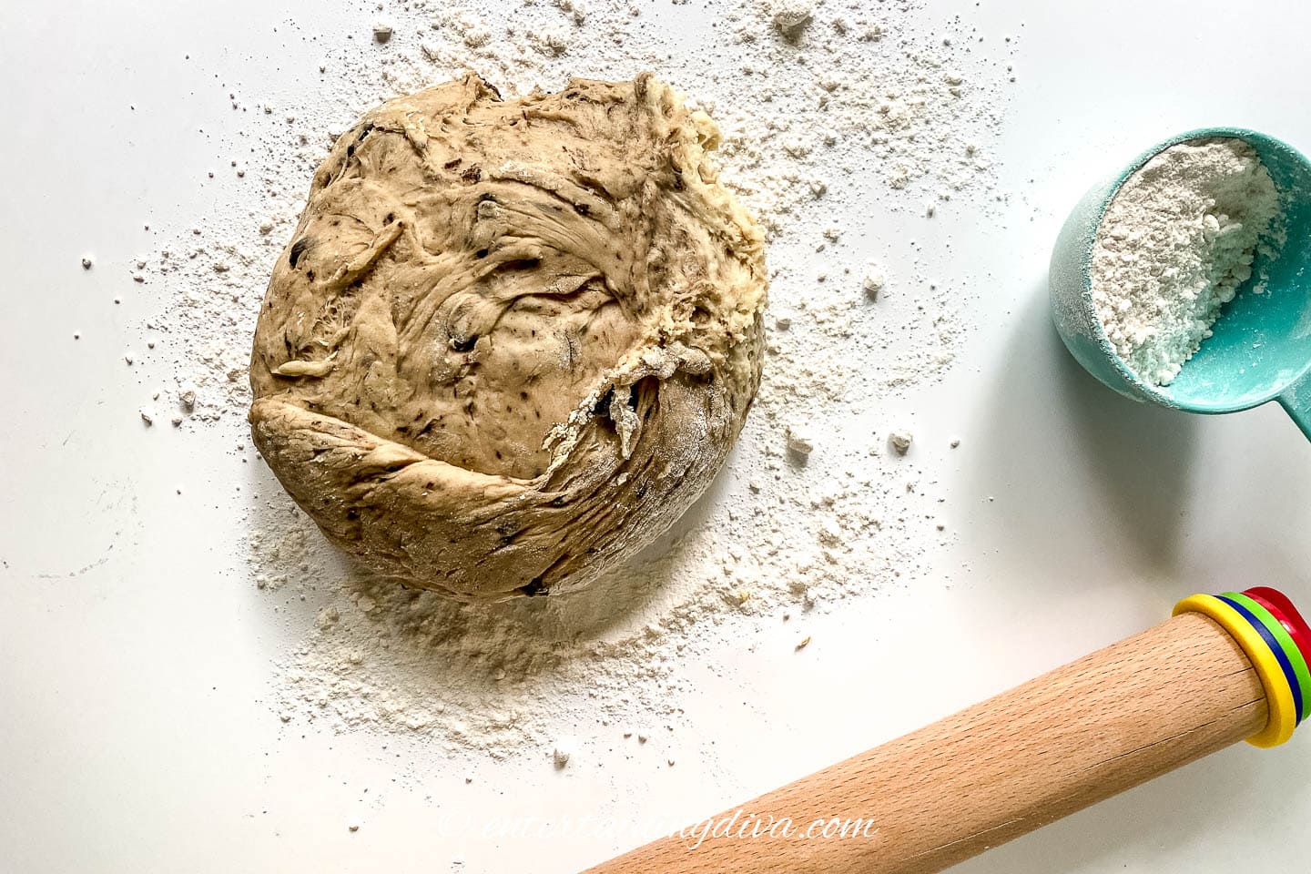 Oreo cinnamon roll dough on a floured countertop with a rolling pin