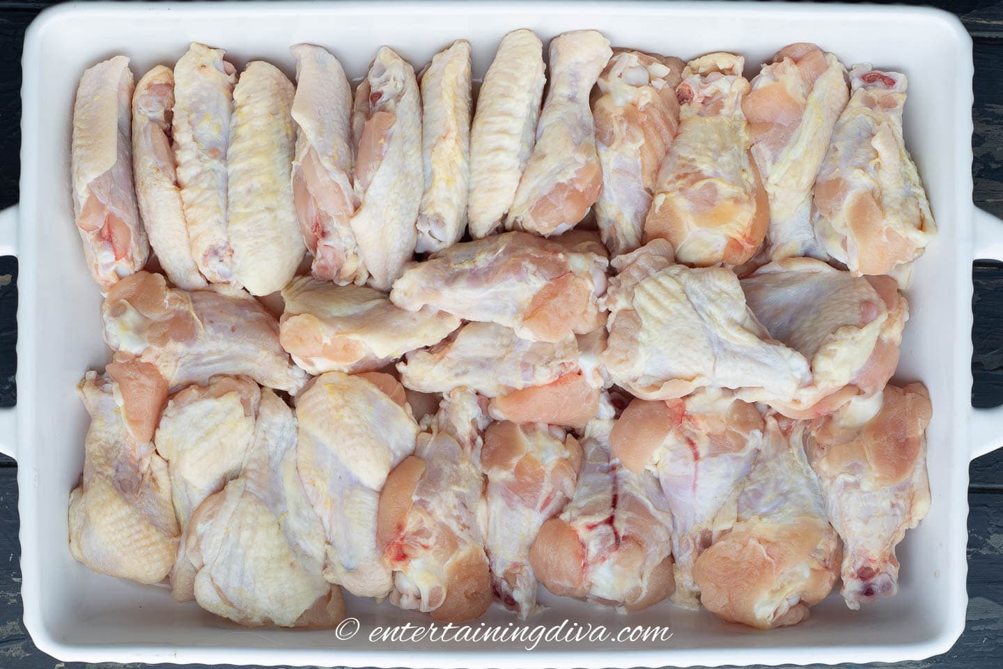 uncooked wings arranged in a baking dish