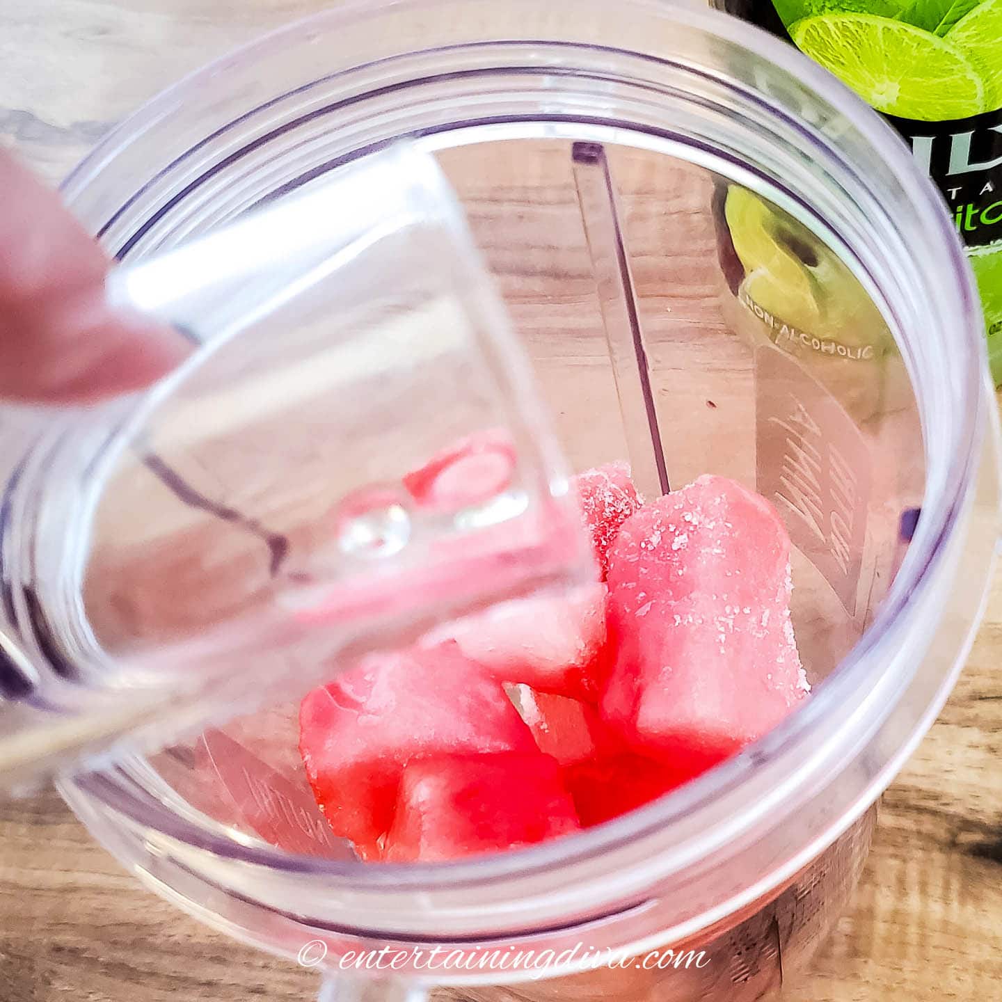 frozen watermelon in a blender with tequila being added