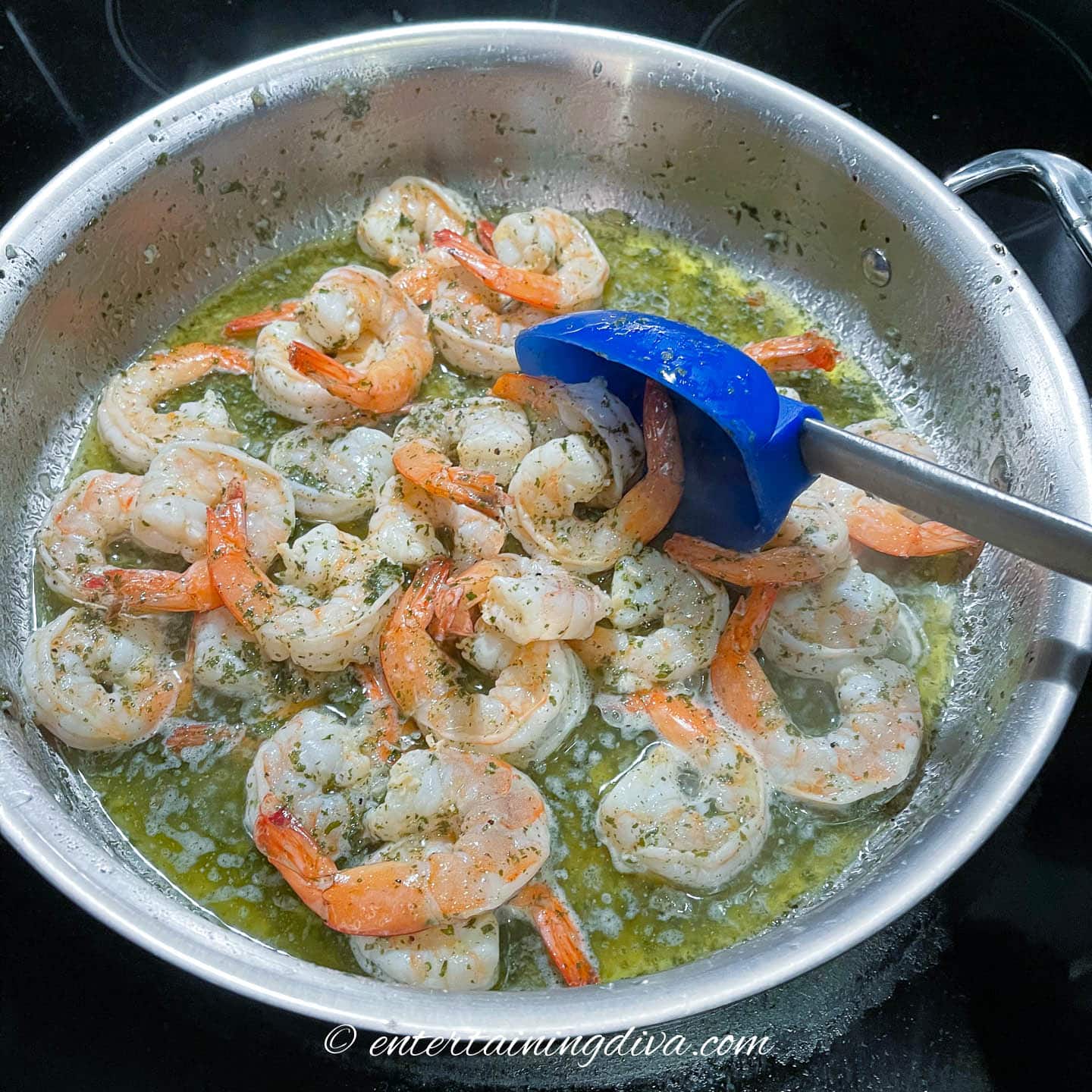 shrimp cooking in lemon garlic butter sauce in a frying pan