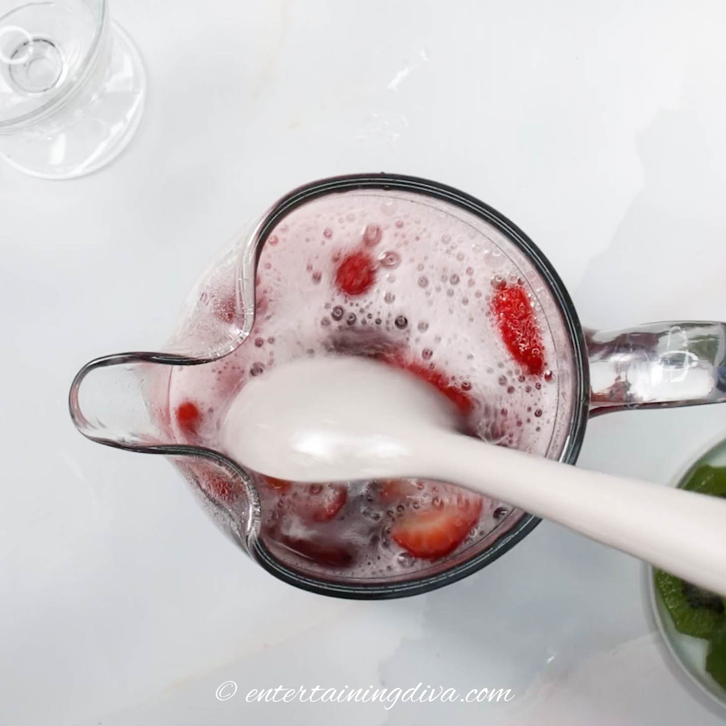 Spoon stirring Sangria in a pitcher