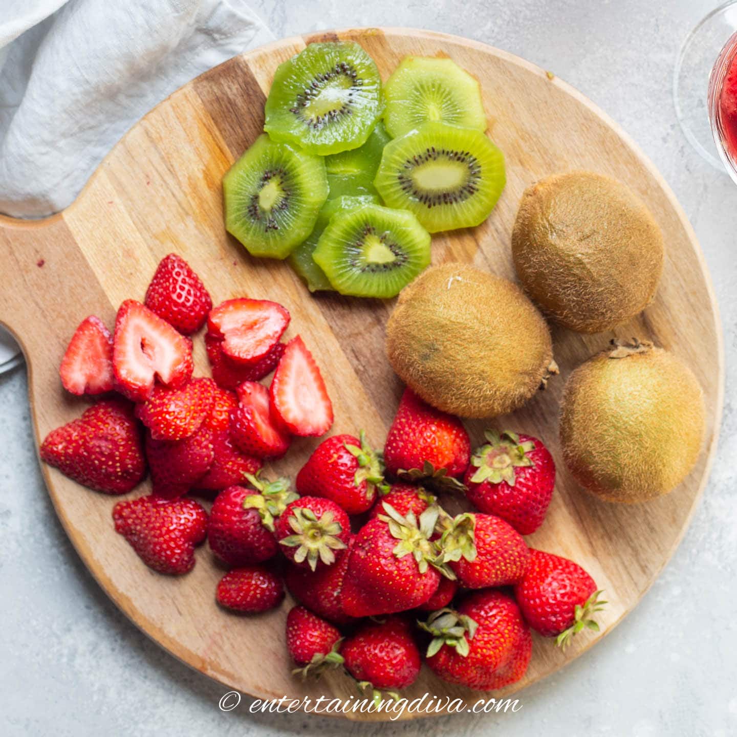 sliced strawberries and kiwis on a cutting board