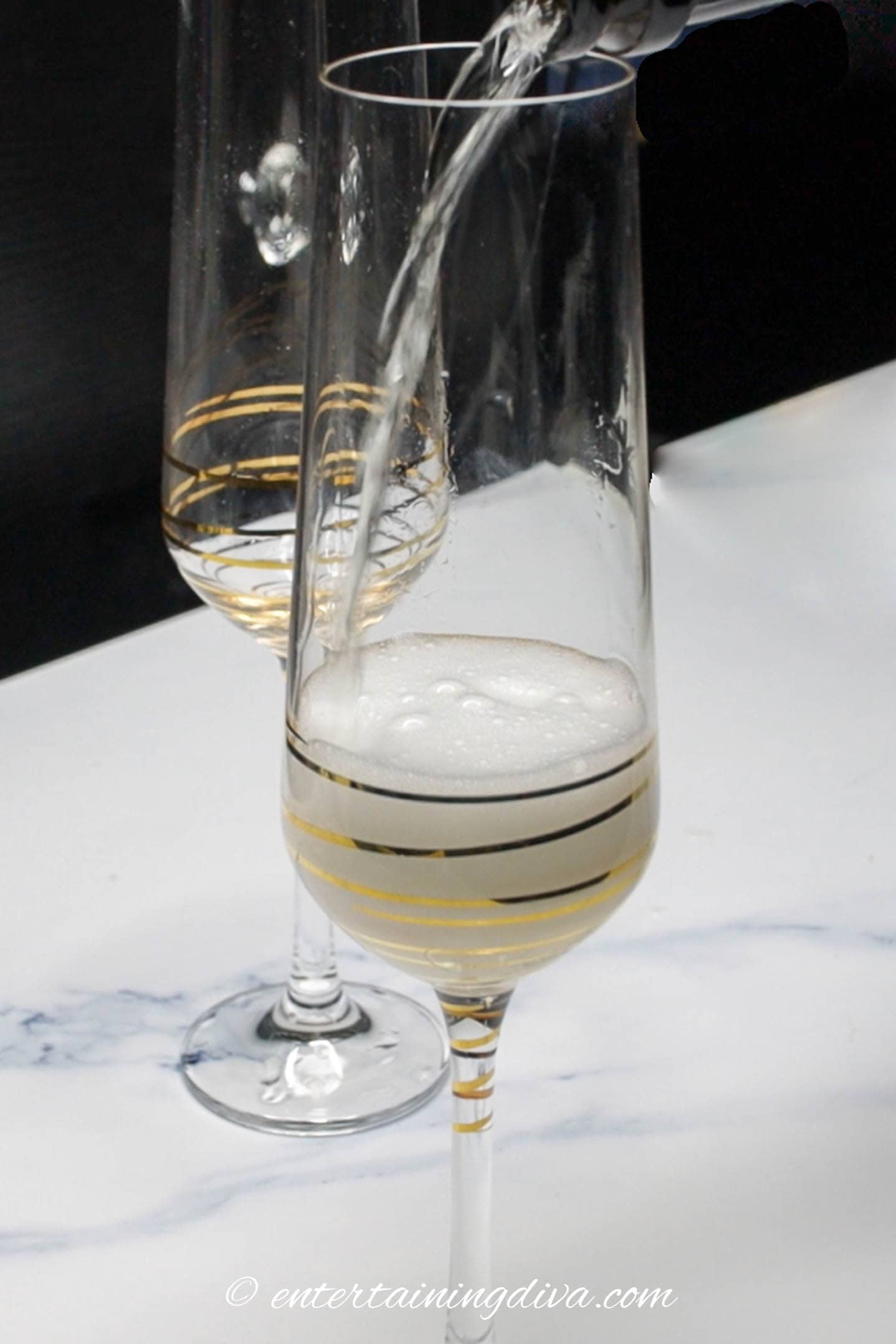 champagne glass being filled with sparkling wine