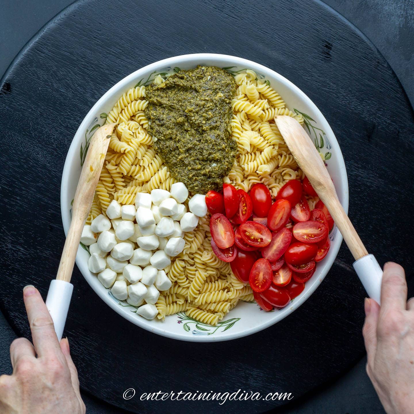 rotini pasta, pesto, mozzarella pearls and grape tomatoes in a bowl