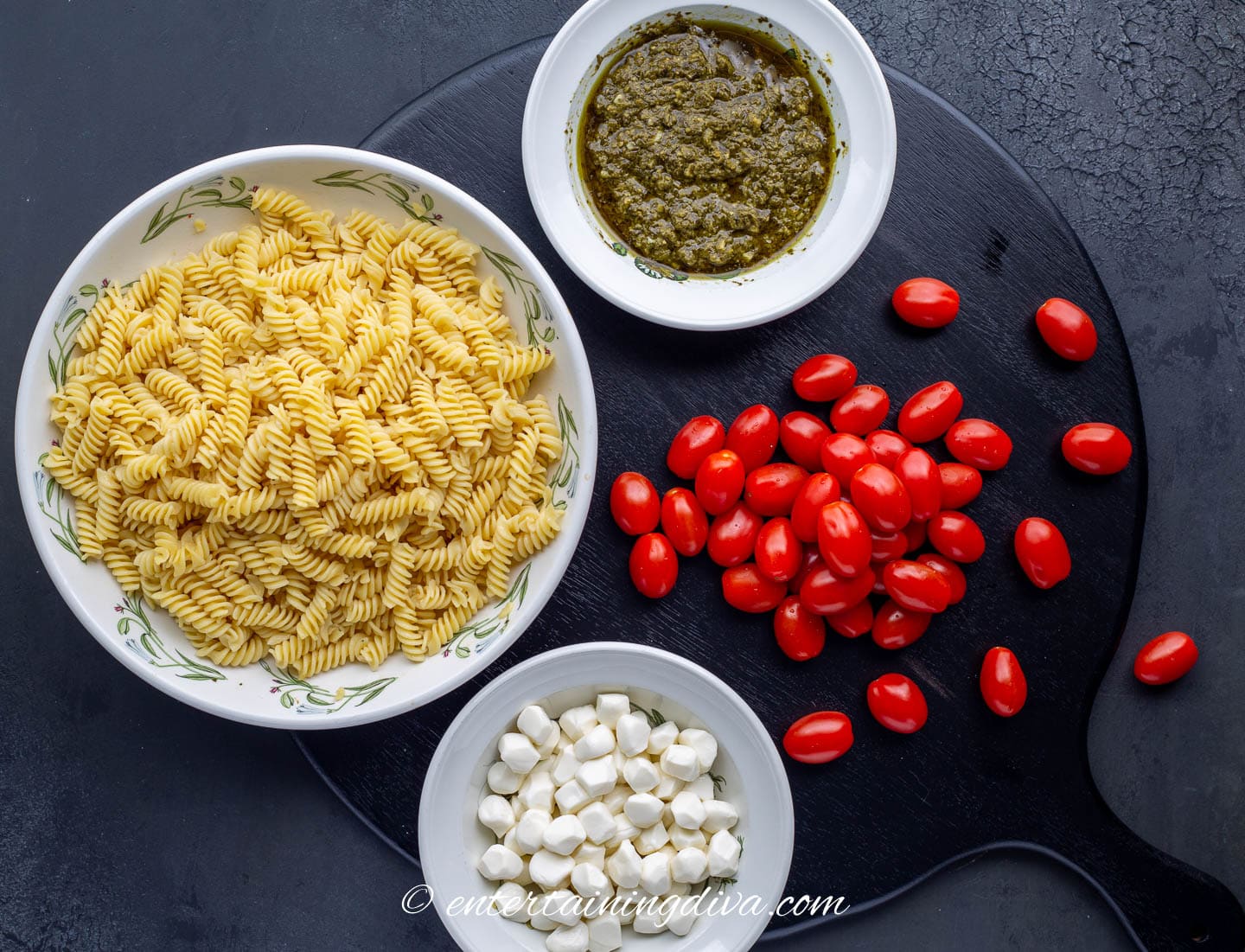 ingredients for 4-ingredient caprese pasta salad - rotini pasta, mozzarella pearls, grape tomatoes and basil pesto