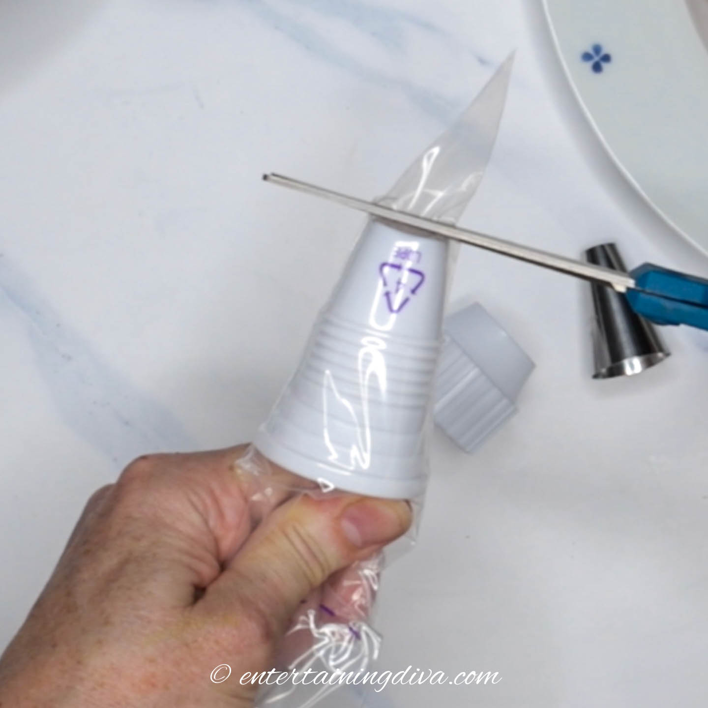 scissors cutting off the end of a piping bag