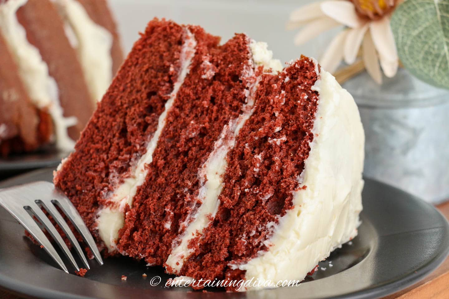 A piece of red velvet cake on a plate with a fork