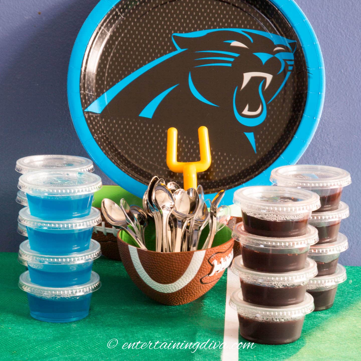 blue and black jello shots with a bowl of appetizer spoons in front of a Panthers plate