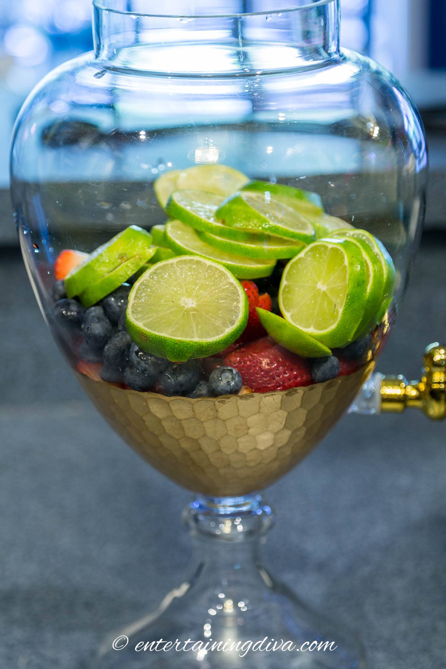 berries and limes in a drink dispenser