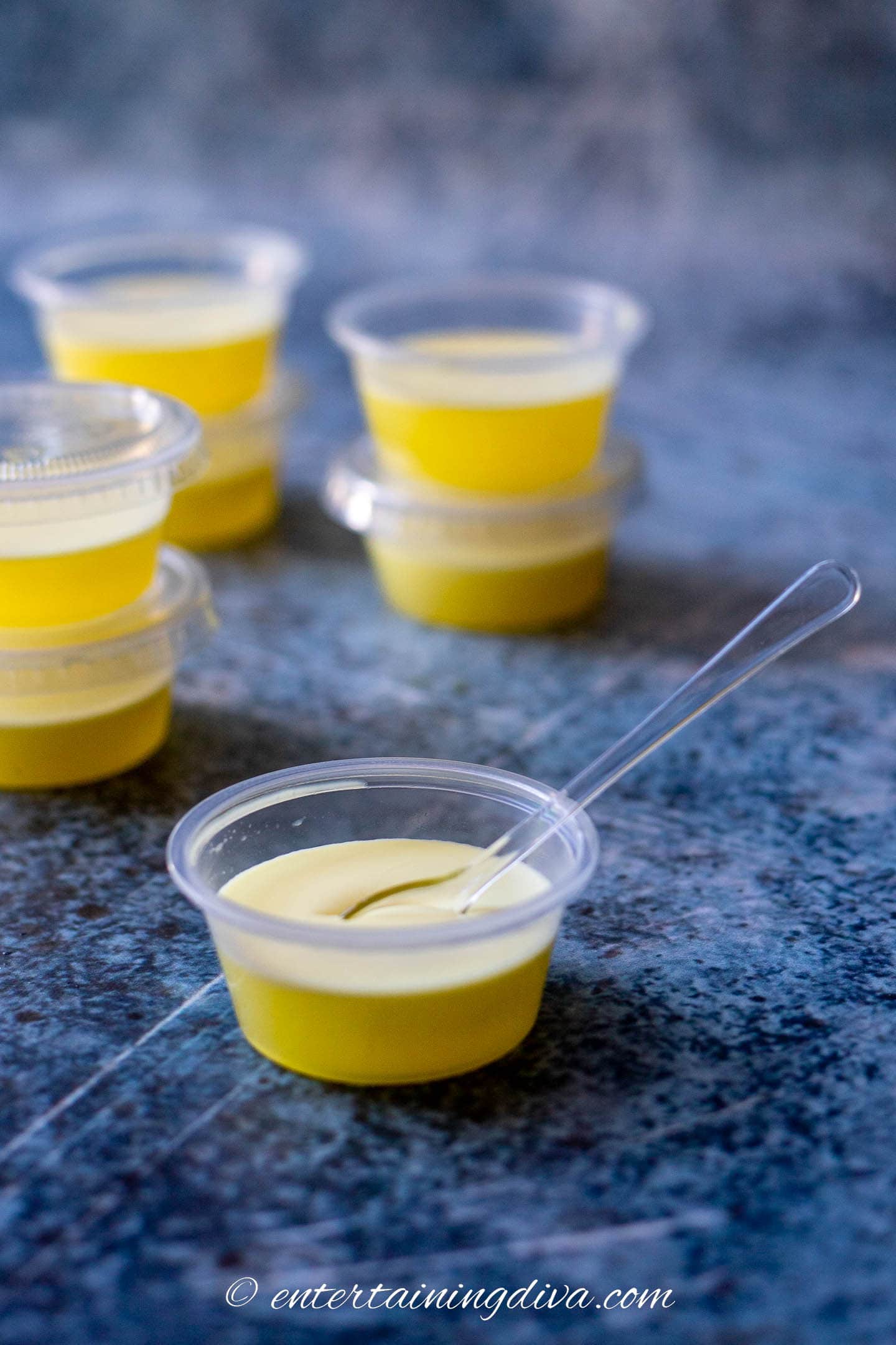 Creamy piña colada jello shot with an appetizer spoon dipped in it