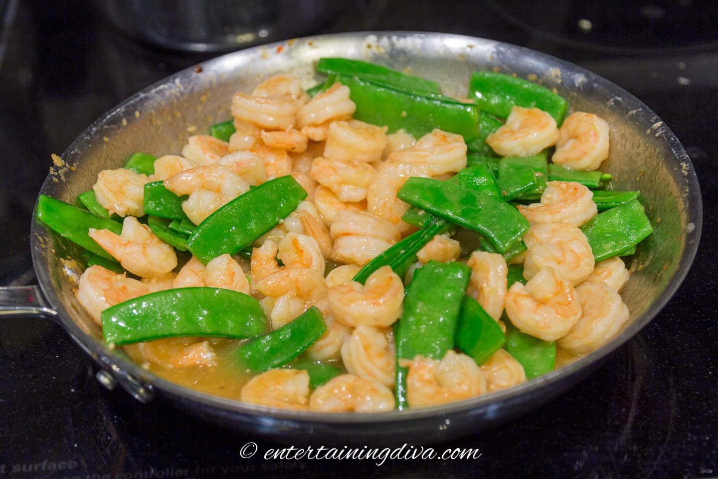 shrimp and snow peas in a frying pan