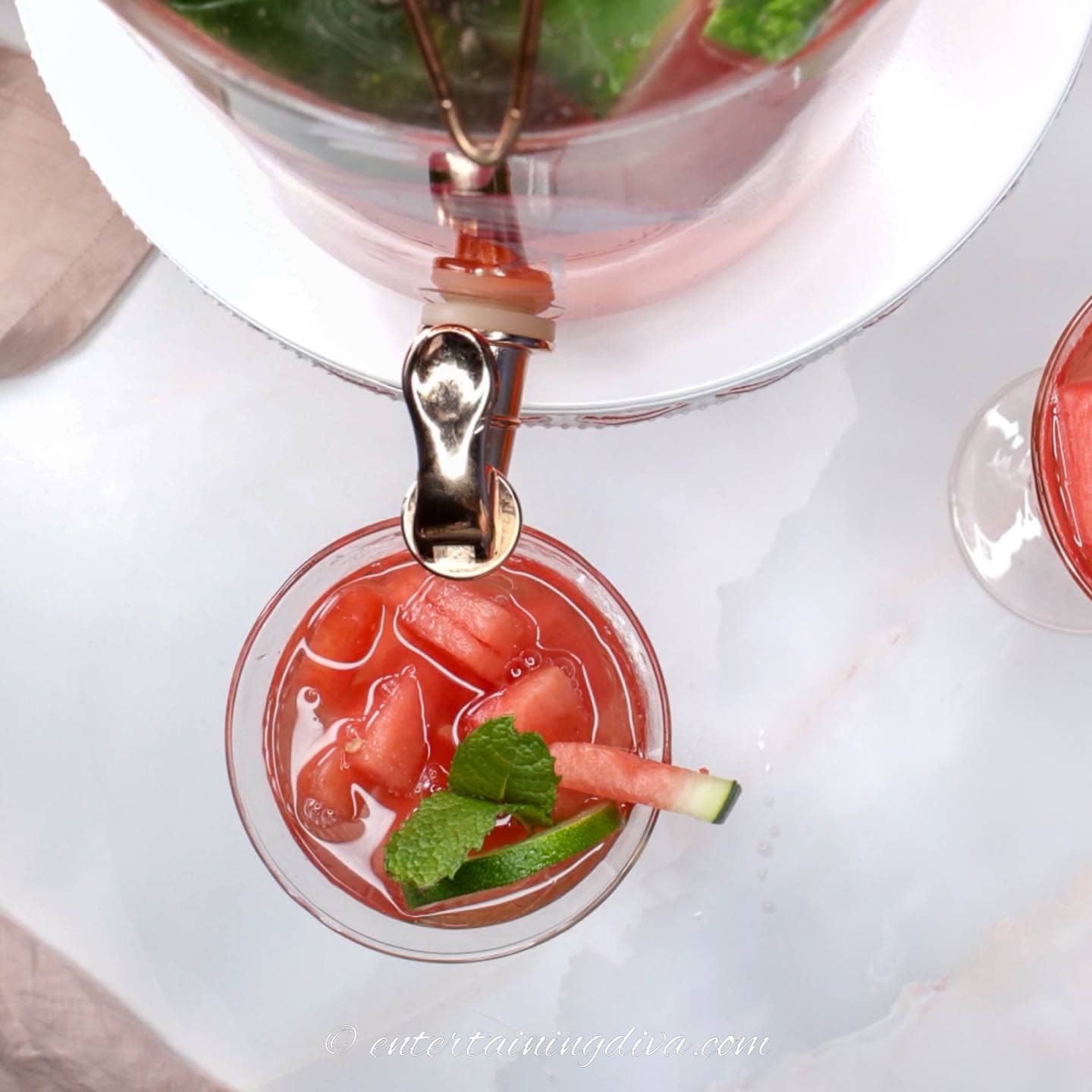 overhead view of glass with watermelon sangria and watermelon, lime and mint garnishes