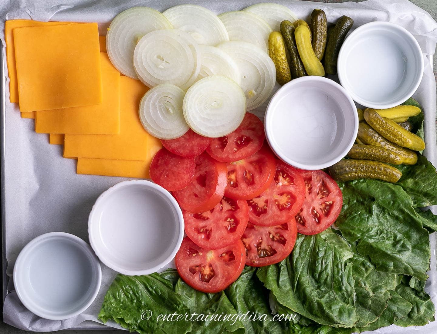 how to make a burger toppings board step 6: bowls, lettuce, cheese, tomatoes, onions, and dill pickles