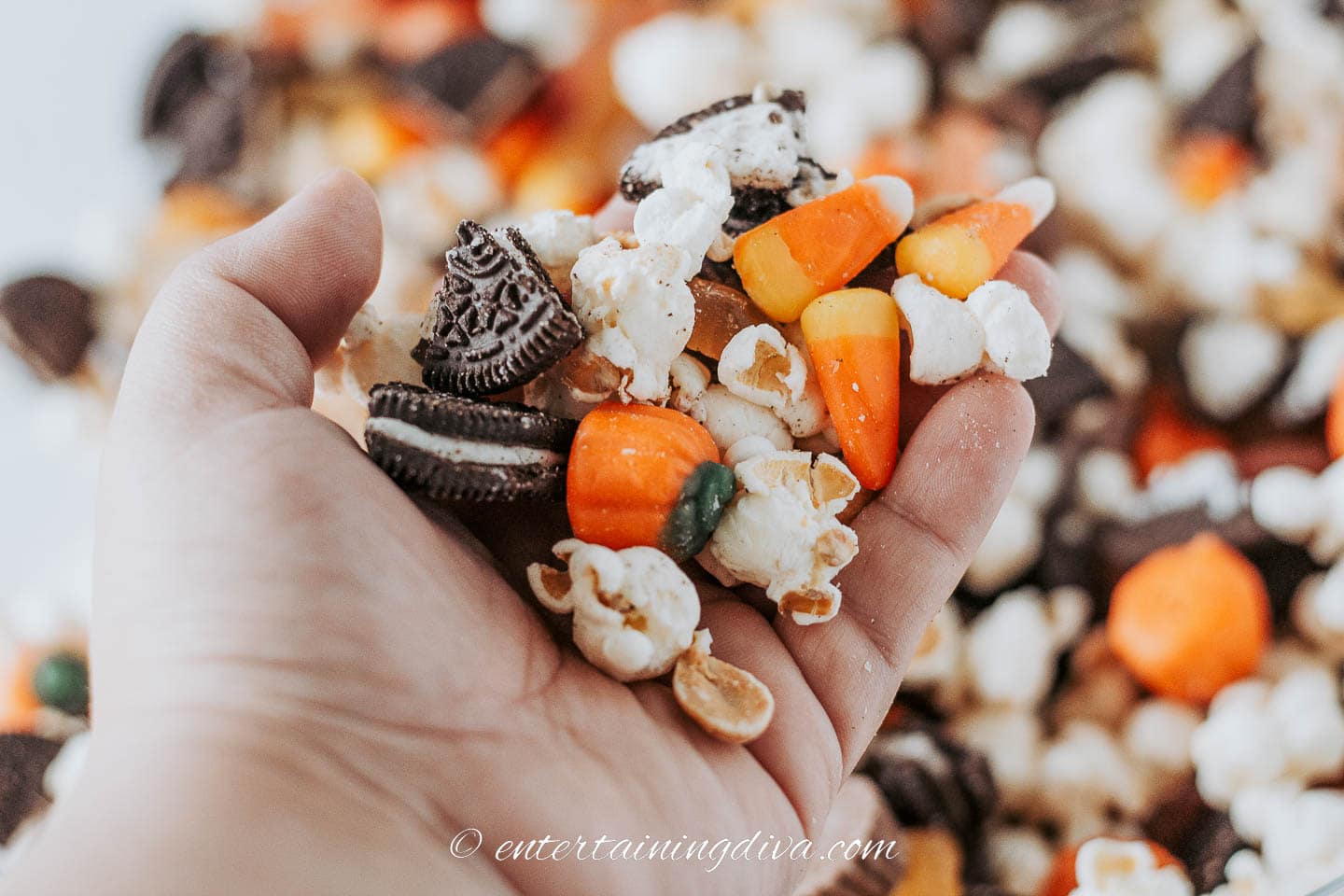 A hand holding Halloween party mix