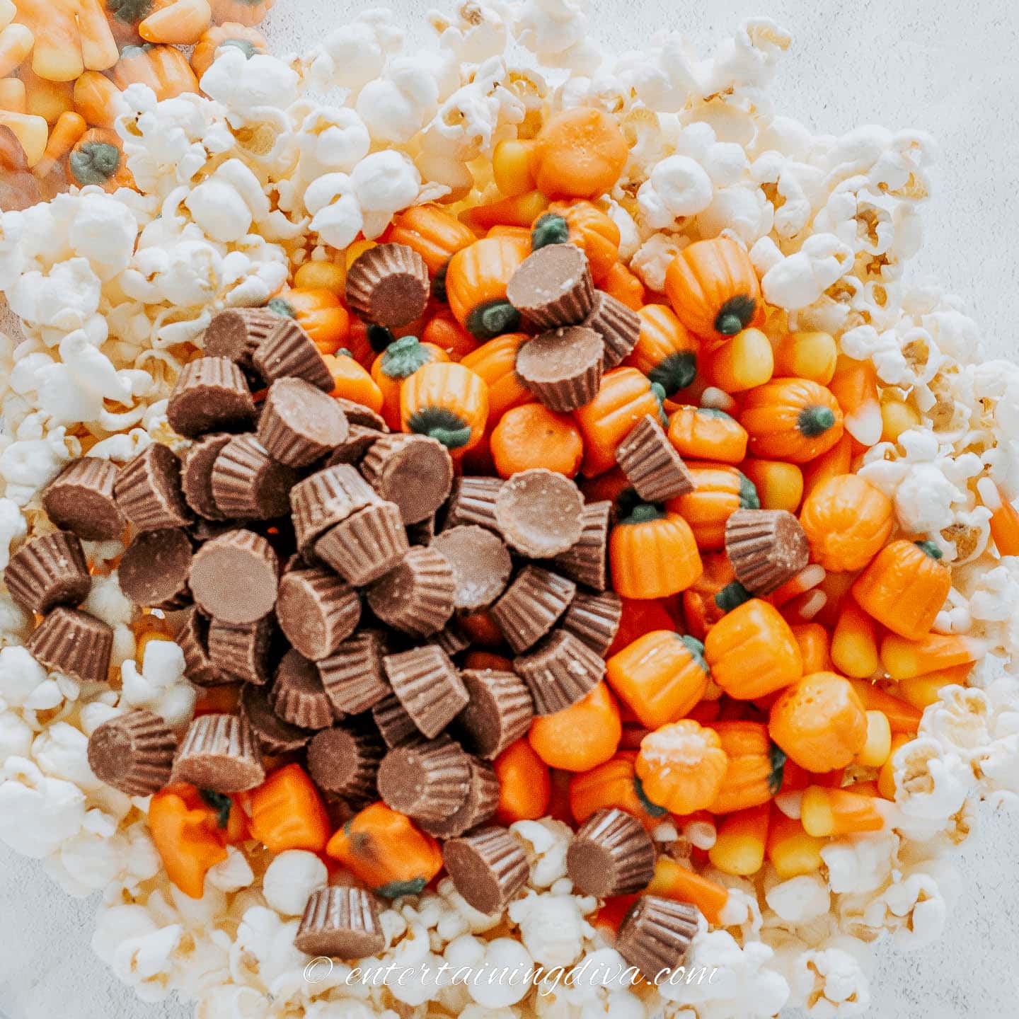Popcorn, candy pumpkins and mini Reese's in a bowl