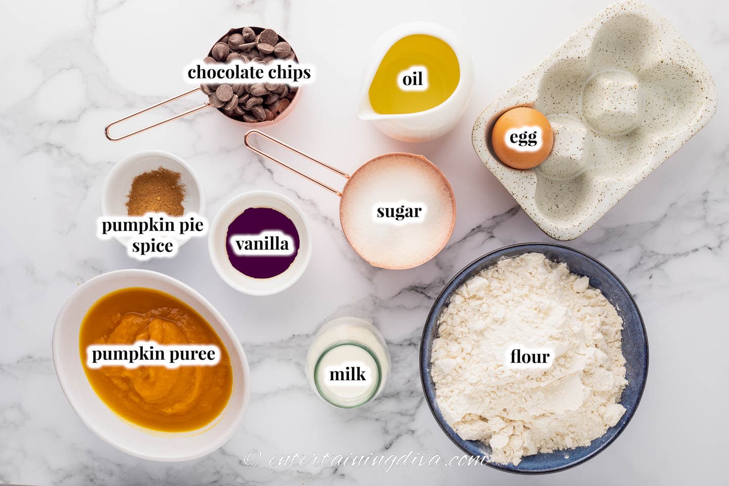 ingredients for pumpkin chocolate chip muffins - flour, sugar, milk, chocolate chips, pumpkin puree, egg, oil, vanilla, pumpkin pie spice