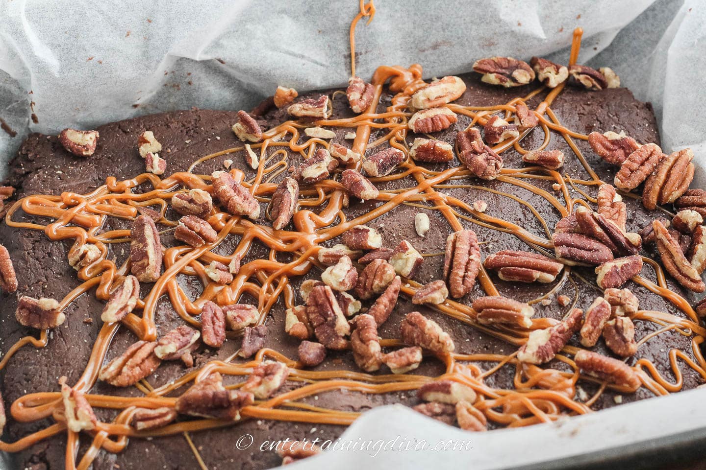 chocolate cream cheese fudge topped with melted caramel and pecans