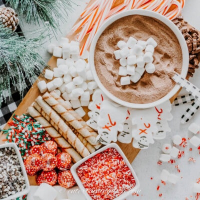 hot chocolate charcuterie board with marshmallows, candy canes, sprinkles and other candies