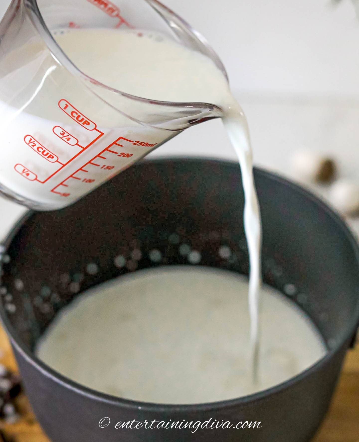 Milk being poured into a sauce pan