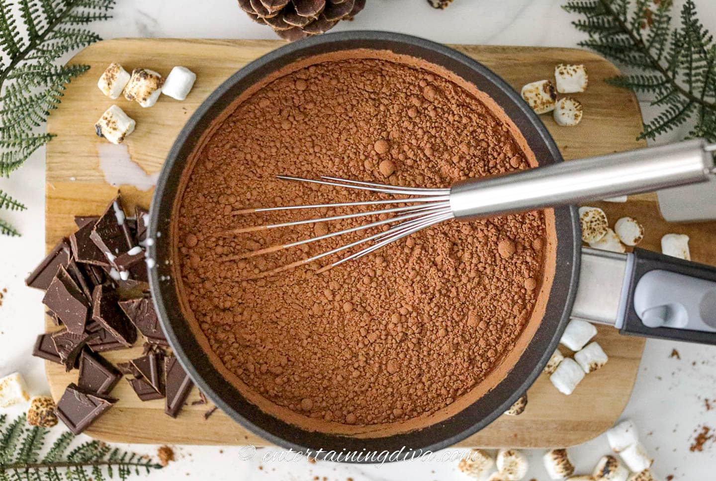 Cocoa powder and milk in a saucepan with a whisk