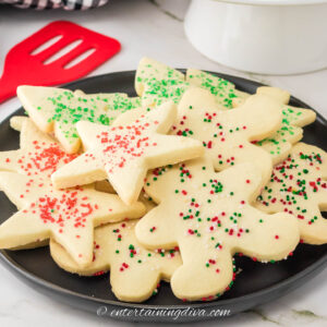 A plate of shortbread Christmas cutout cookies with sprinkles
