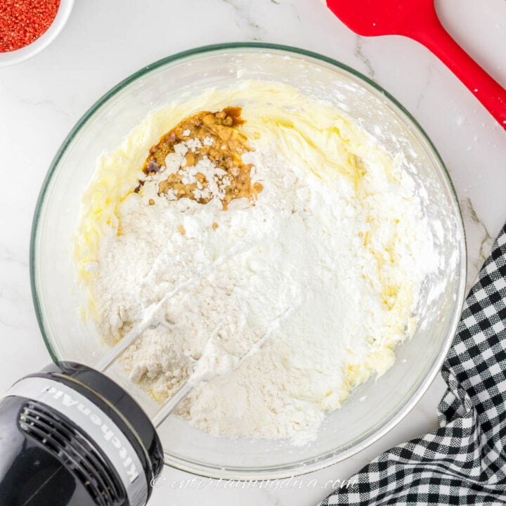 Dry ingredients with whipped butter in a bowl with a mixer
