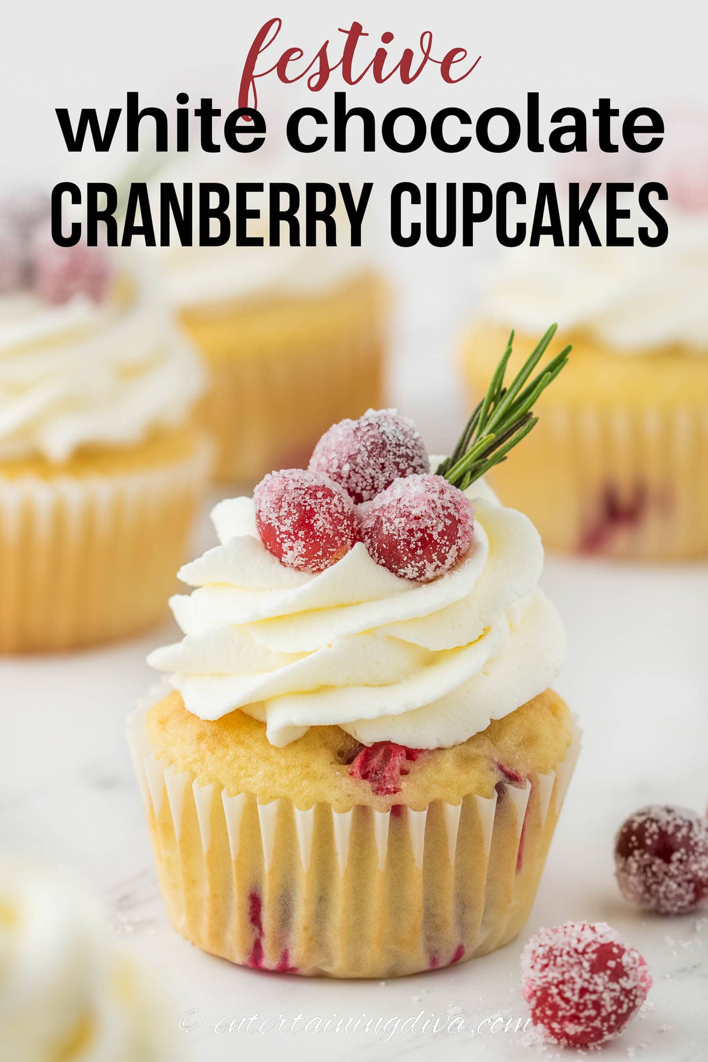 white chocolate cranberry cupcakes with sugared cranberries and rosemary garnish