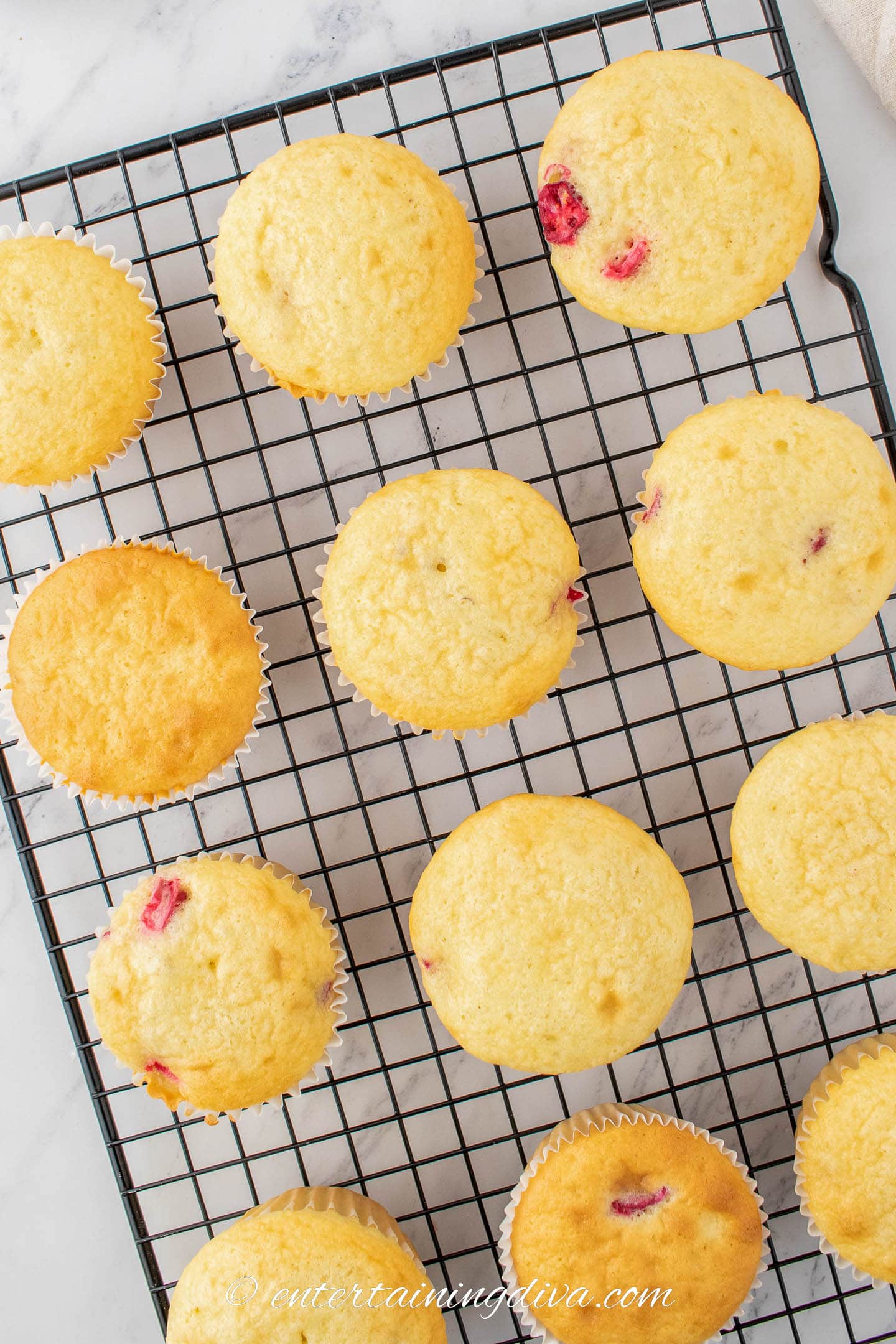 white chocolate cranberry cupcakes on a wire cooling rack