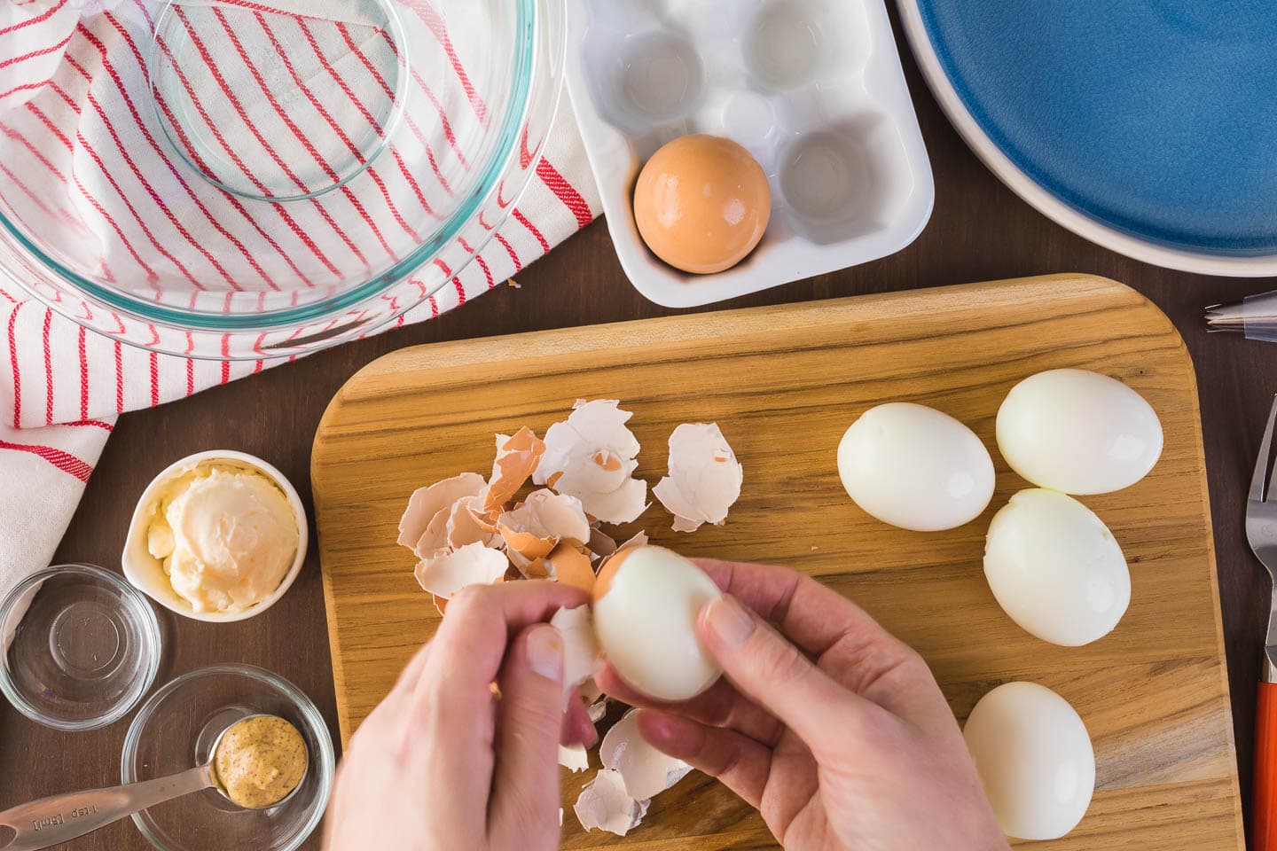 hard boiled eggs being peeled for deviled eggs