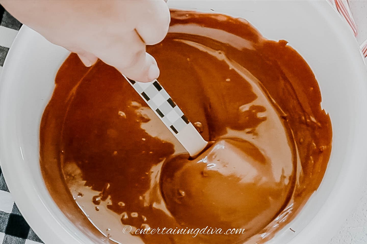 wooden spoon being dipped in melted chocolate