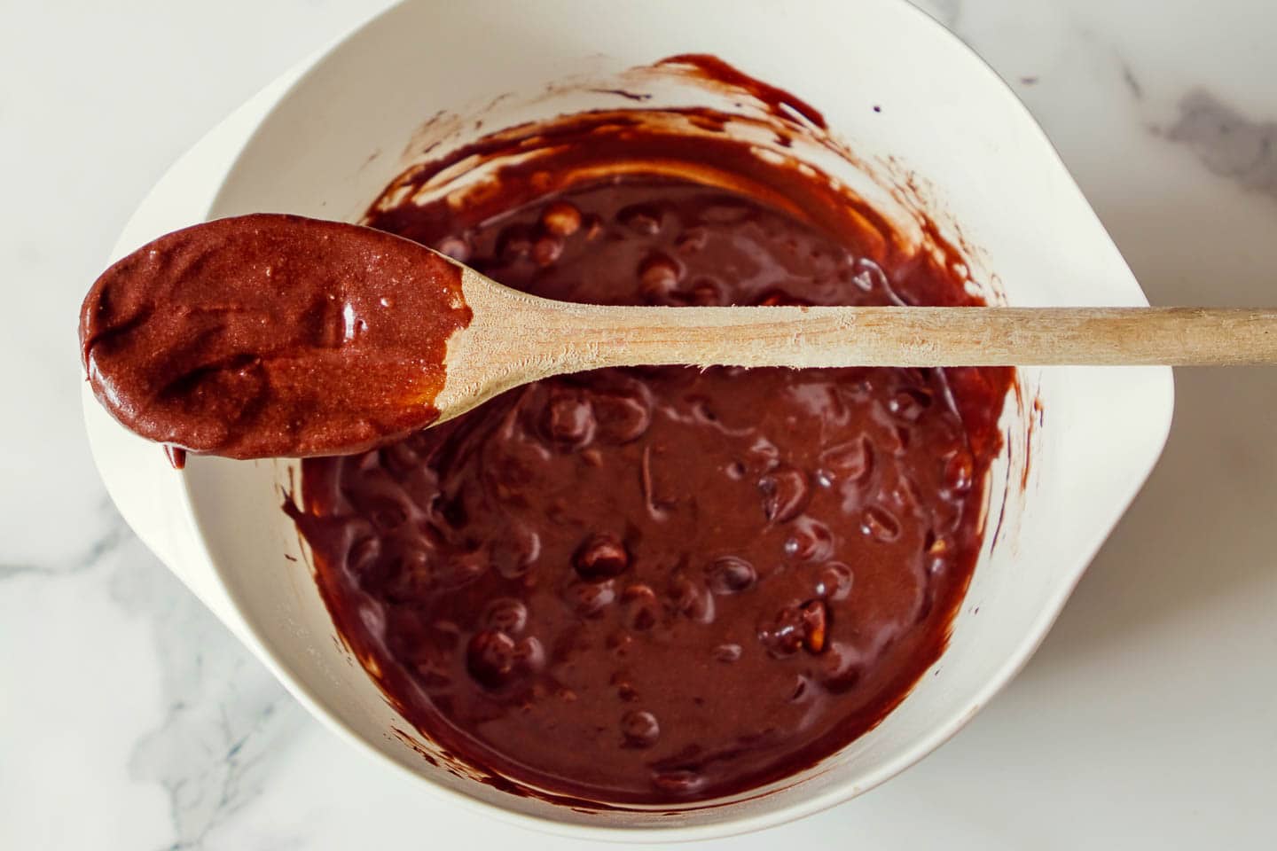 brownie mixture in a bowl with a mixing spoon on top