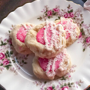 a stack of white chocolate peppermint thumbprint cookies on a plate