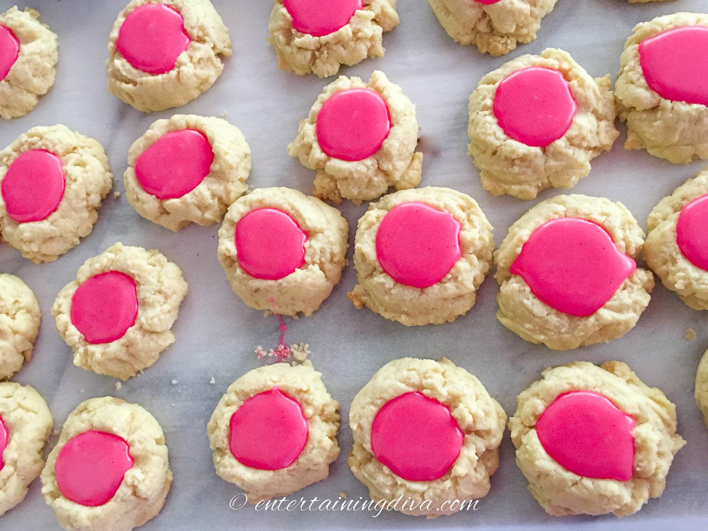 thumbprint cookies filled with pink white chocolate peppermint ganache filling