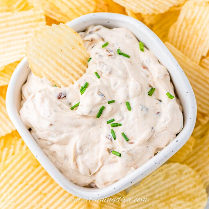 Overhead shot of a chip in a bowl of caramelized onion dip