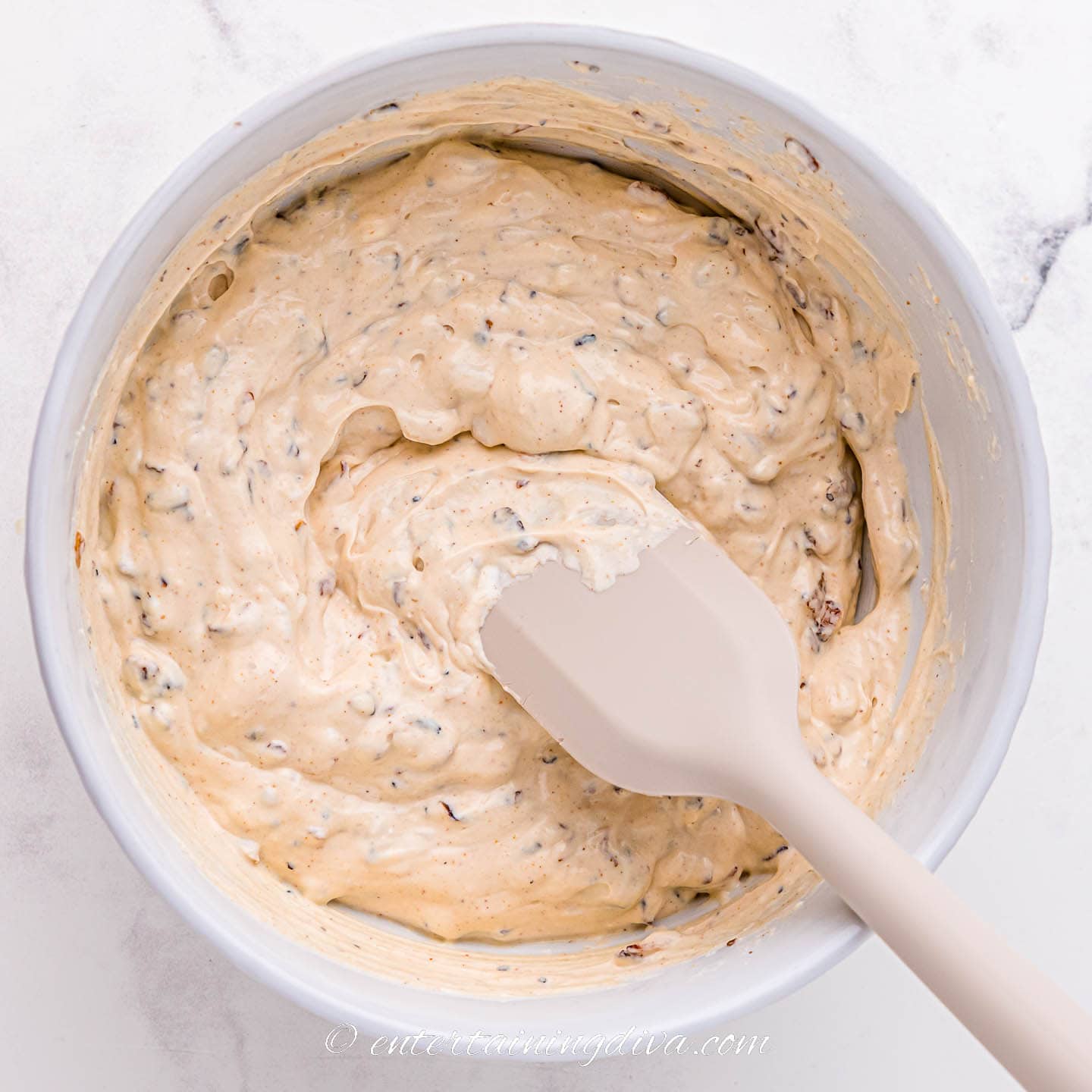 Mixed caramelized onion dip in a bowl with a spoon