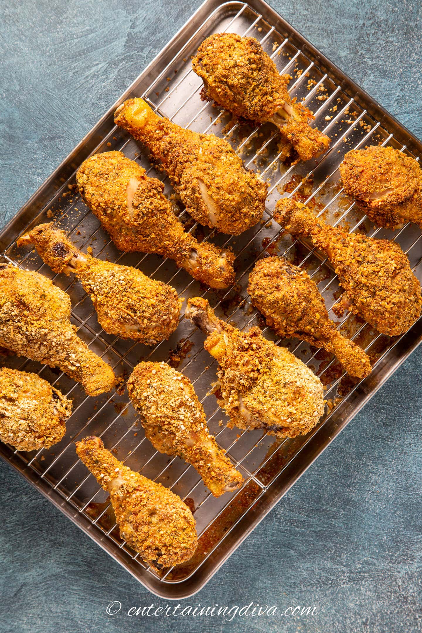 oven baked breaded chicken legs on a baking sheet after coming out of the oven