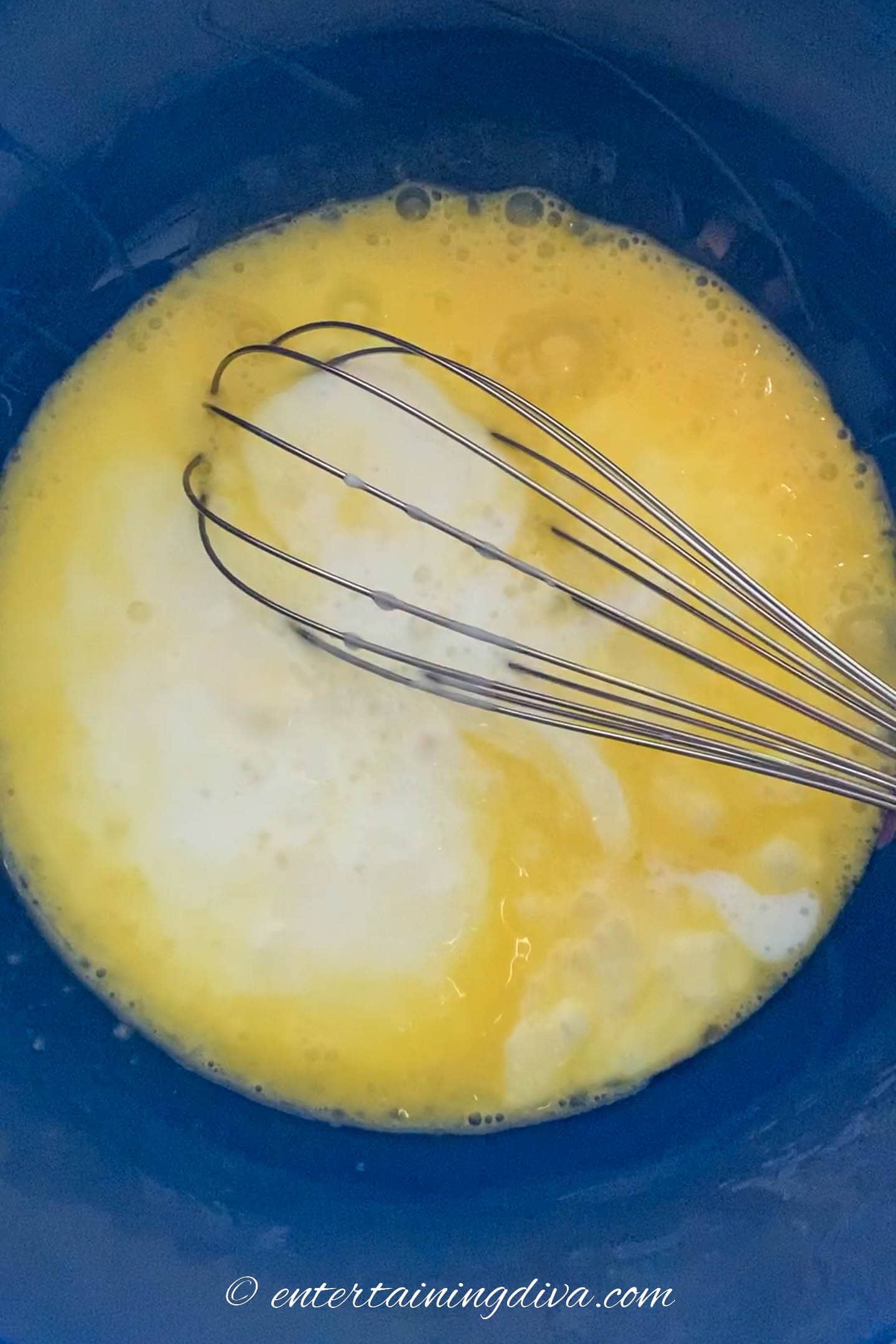 eggs, buttermilk and butter being mixed together in a bowl