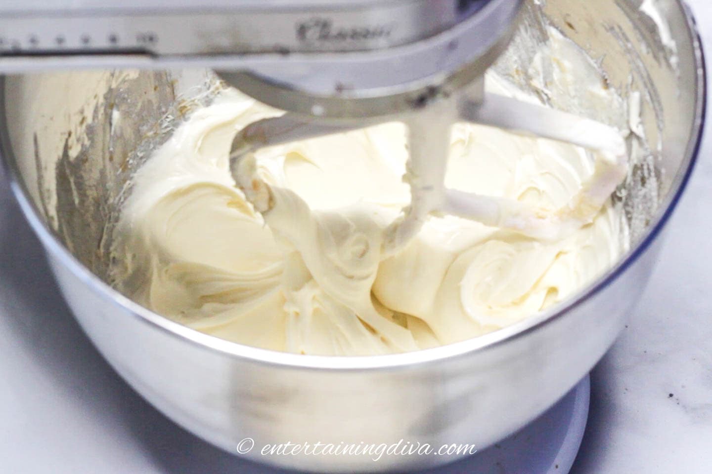 cream cheese being mixed in a bowl