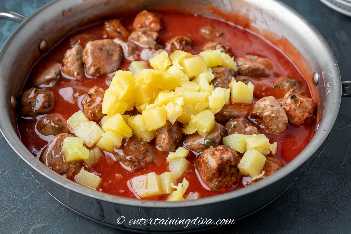 Sweet and sour meatballs with pineapple chunks in a saucepan