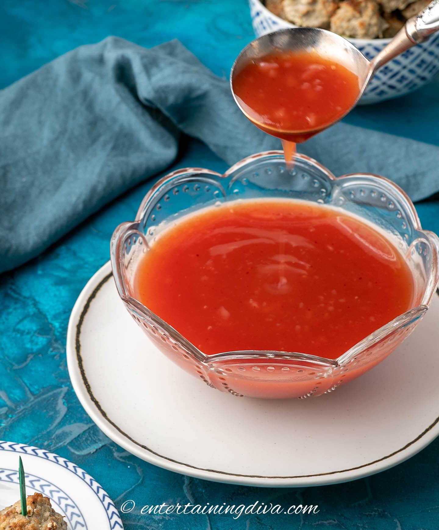 Sweet and sour sauce being spooned out of a bowl