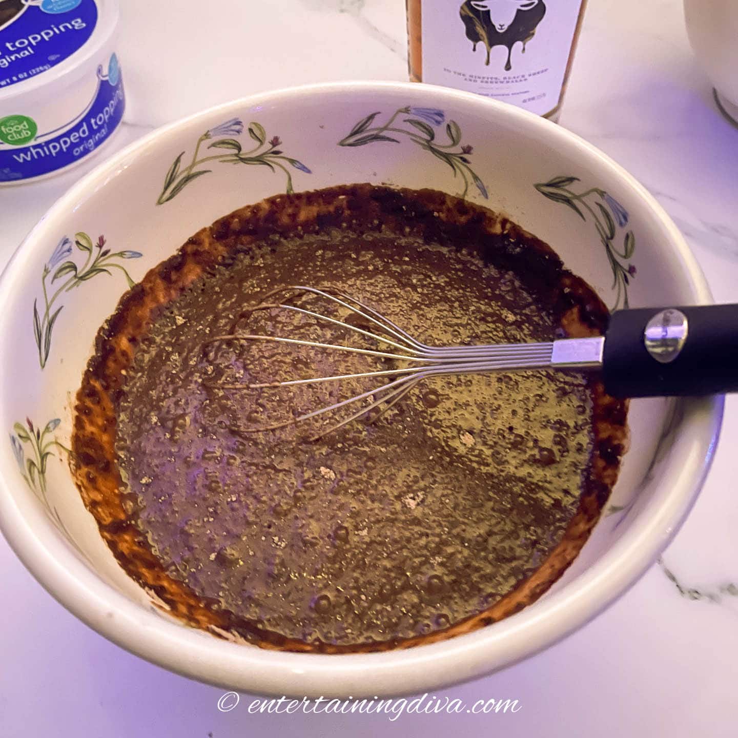 Chocolate pudding mix in a bowl with a whisk