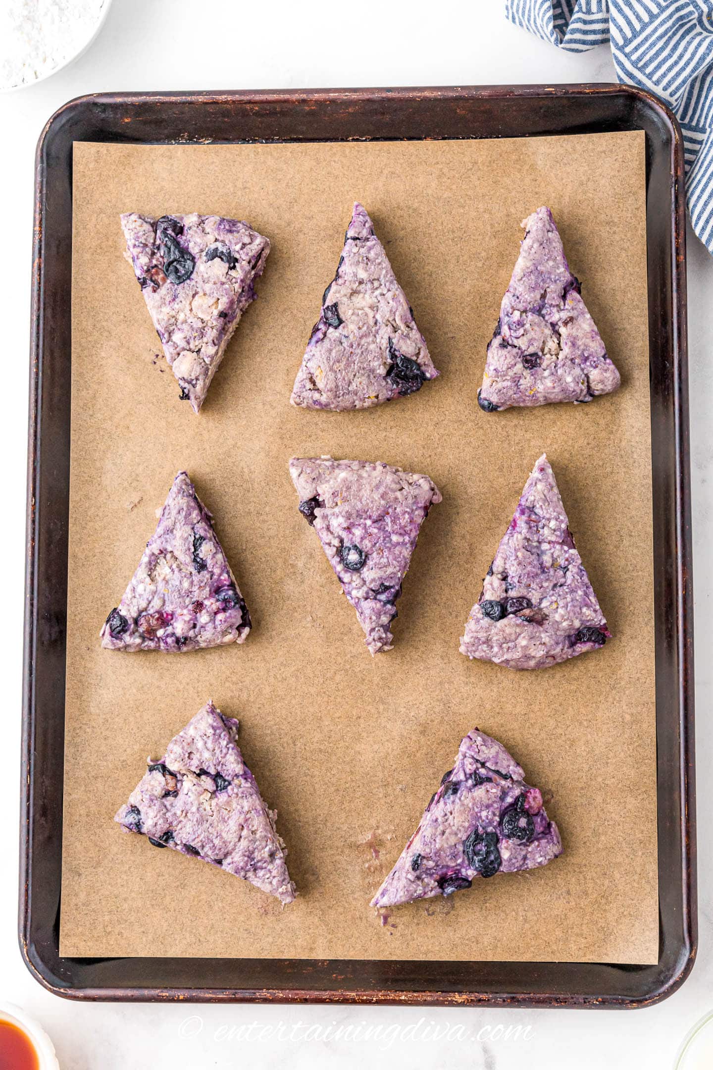 lemon blueberry scones on a parchment-lined baking sheet before baking