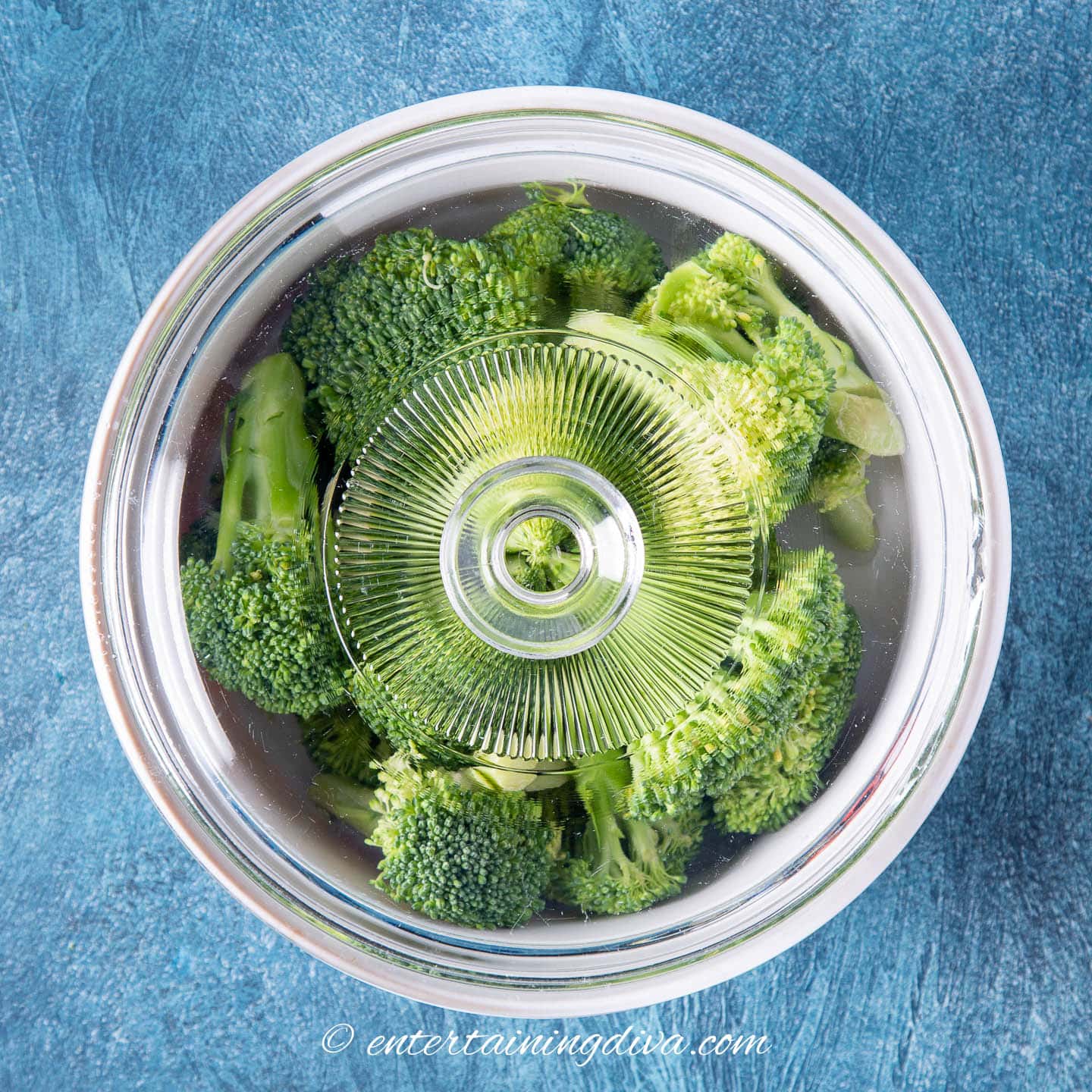 broccoli florets in a microwaveable baking dish with a lid