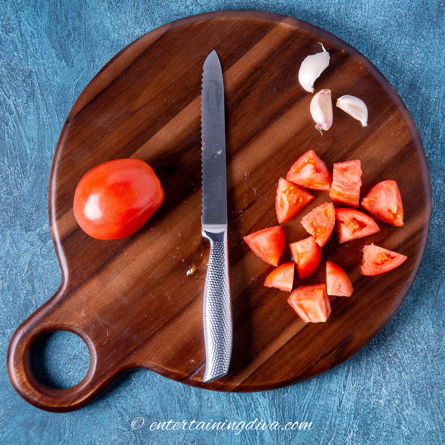 tomatoes and garlic being prepped on a cutting board